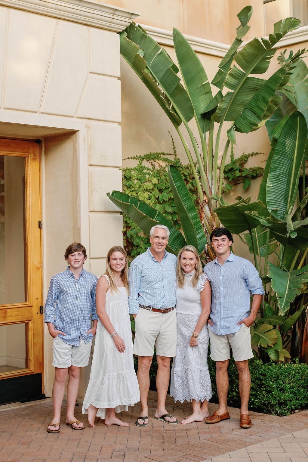 A family of five smiling for a family photo session at Pelican Hill,  California.