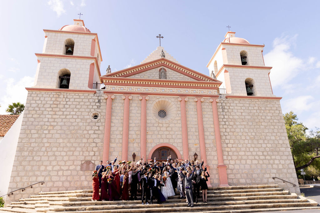 Wedding party and guests standing on the steps in front at Mission Santa Barbara wedding | Photo by Sarah Block Photography