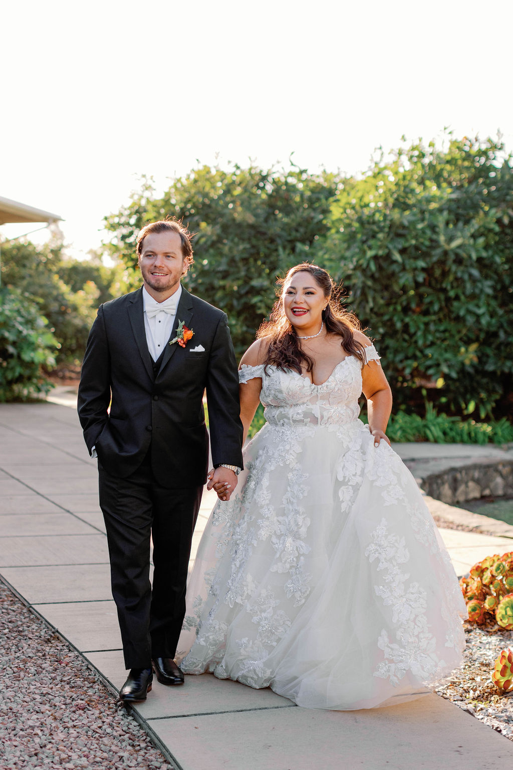 Happy bride and groom walking together at Mission Santa Barbara wedding | Photo by Sarah Block Photography