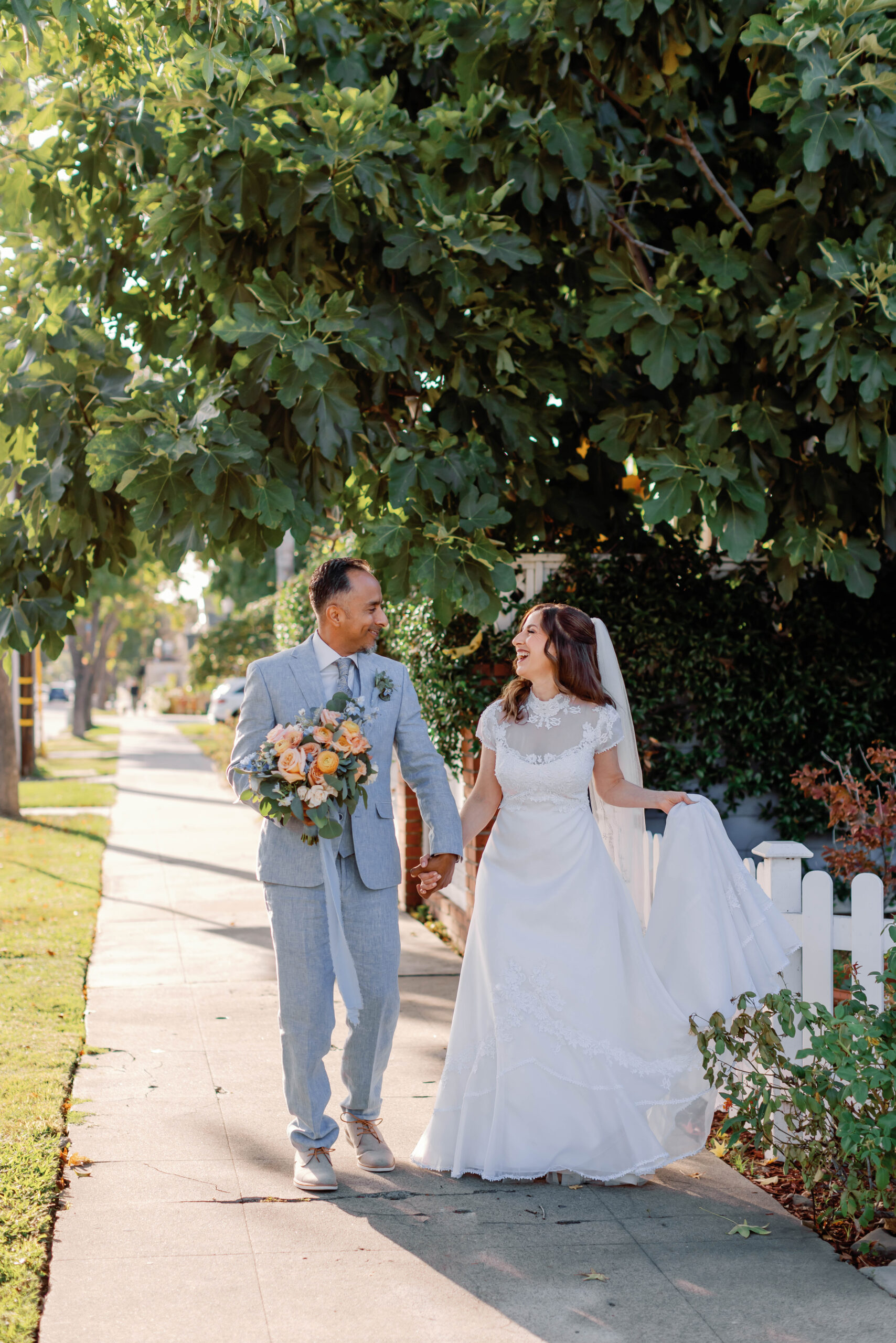 Bride and groom walking hand in in hand | Photo by Sarah Block Photography