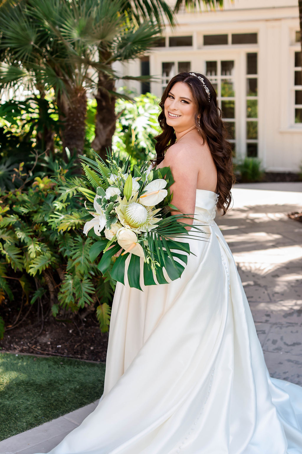 Closeup of the bride and her bouquet at The Hotel Del Coronado in San Diego. Standing outside surrounded by palm trees. Photo by Sarah Block Photography.