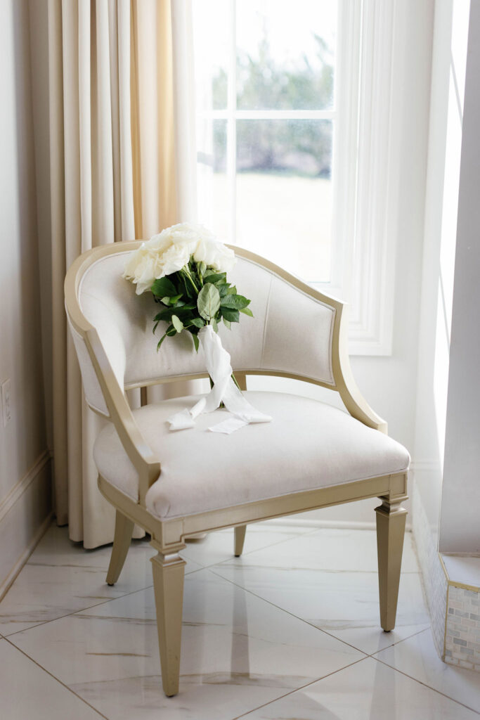 Photo of the brides white wedding bouquet leaning on the chair in a detail shot at the wedding venue Hillside Estate in Dallas Texas | Photo by Texas Photographer Sarah Block Photography