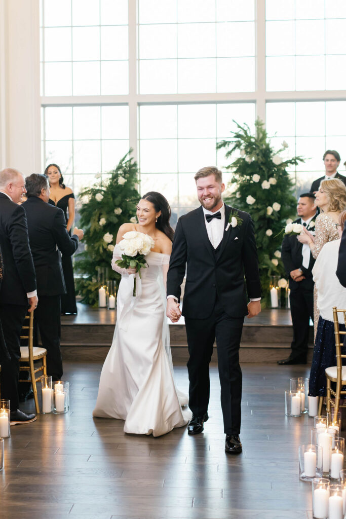 Bride and groom as they walk down the aisle together hand and hand at the Hillside Estate indoor ceremony at a venue in Dallas Texas. | Photo by Texas Photographer Sarah Block Photography
