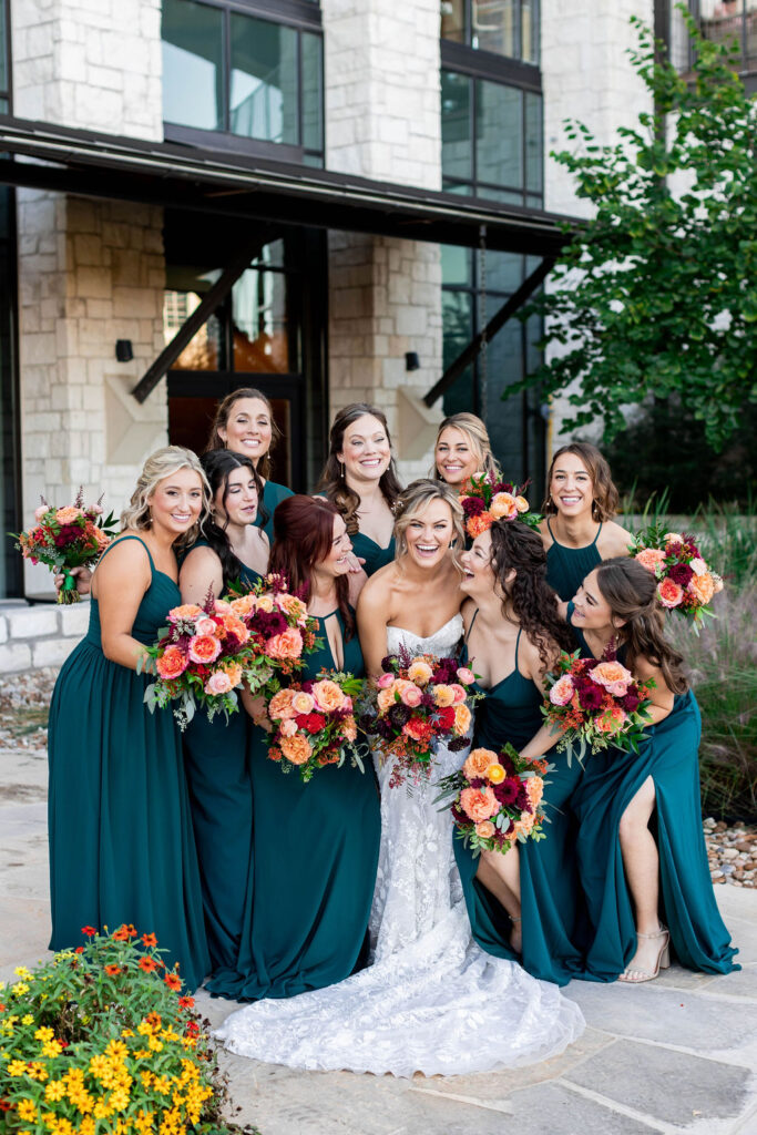 Bridal party gathers around the bride in their sea green colored bridesmaids dresses at the Omni Barton Creek Resort in Austin Texas | Photo by Texas Photographer Sarah Block Photography