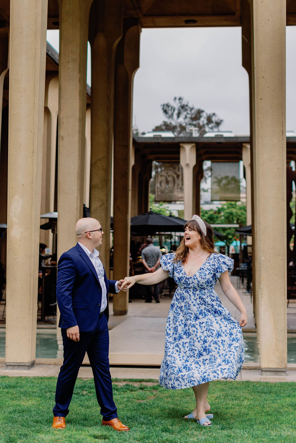 Engagement photo of Jimmy and Hannah dancing outside at the San Diego Museum of art. |Photo by California Photographer Sarah Block Photography