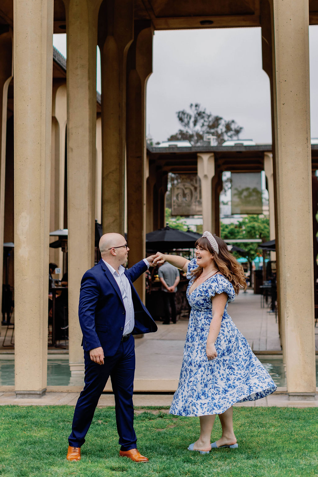 Engagement photo of Jimmy and Hannah  dancing and Jimmy is twirling her at San Diego Museum of art. |Photo by California Photographer Sarah Block Photography