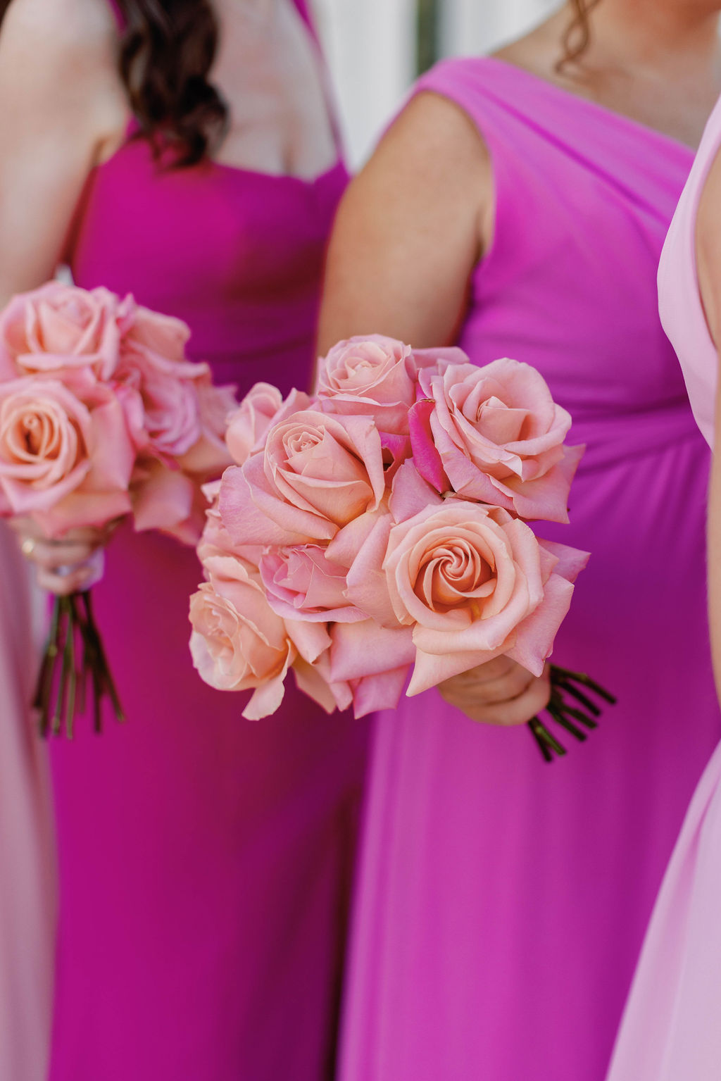 Torso photo of the bridesmaids dressed in Viva Magenta gowns and holding bouquets in mixed shades of pink by their side as they stand at The Grand Lady Wedding Venue in Austin Texas. |Photographer Sarah Block of Sarah Block Photography