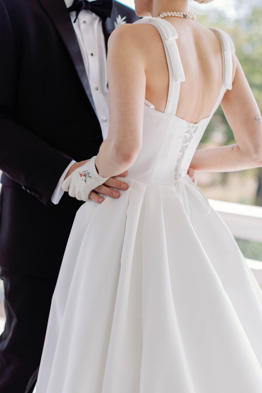 Bride and Groom closeup of their hands together on the brides hips during their first look on the sprawling porch of the Grand Lady Wedding Venue in Austin Texas | Photo by Sarah Block of Sarah Block Photography