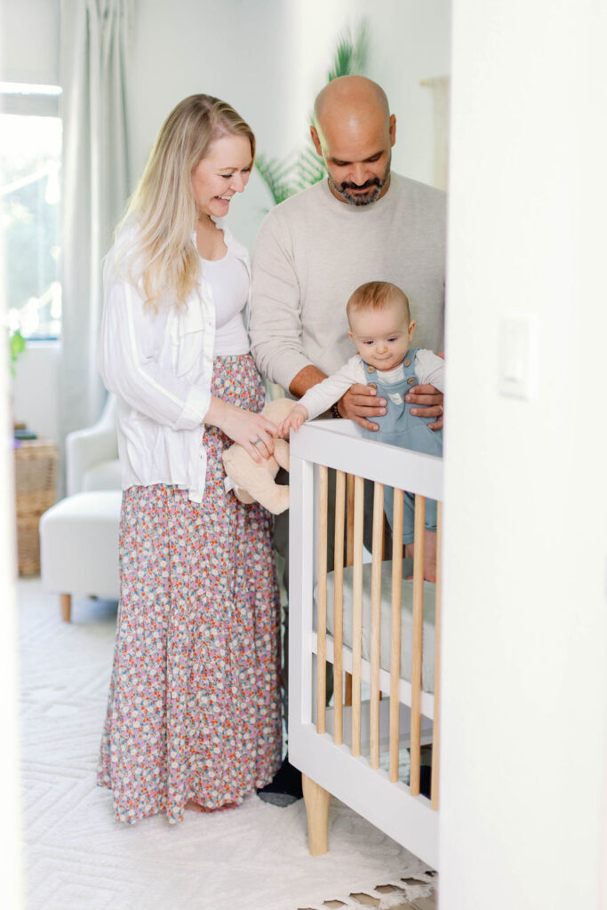 Mom and Dad hold baby Marley in his crib in his nursery. | Photo by California Photographer Sarah Block Photography