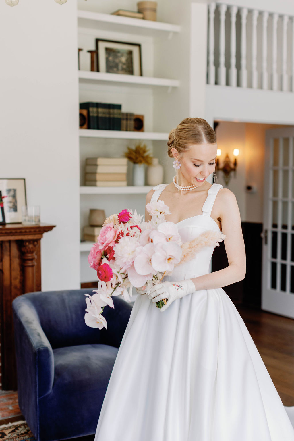The bride is looking down while holding gher wedding bouquet and standing in the library at the Grand Lady Wedding Venue in Austin Texas. |Photographer Sarah Block of Sarah Block Photography