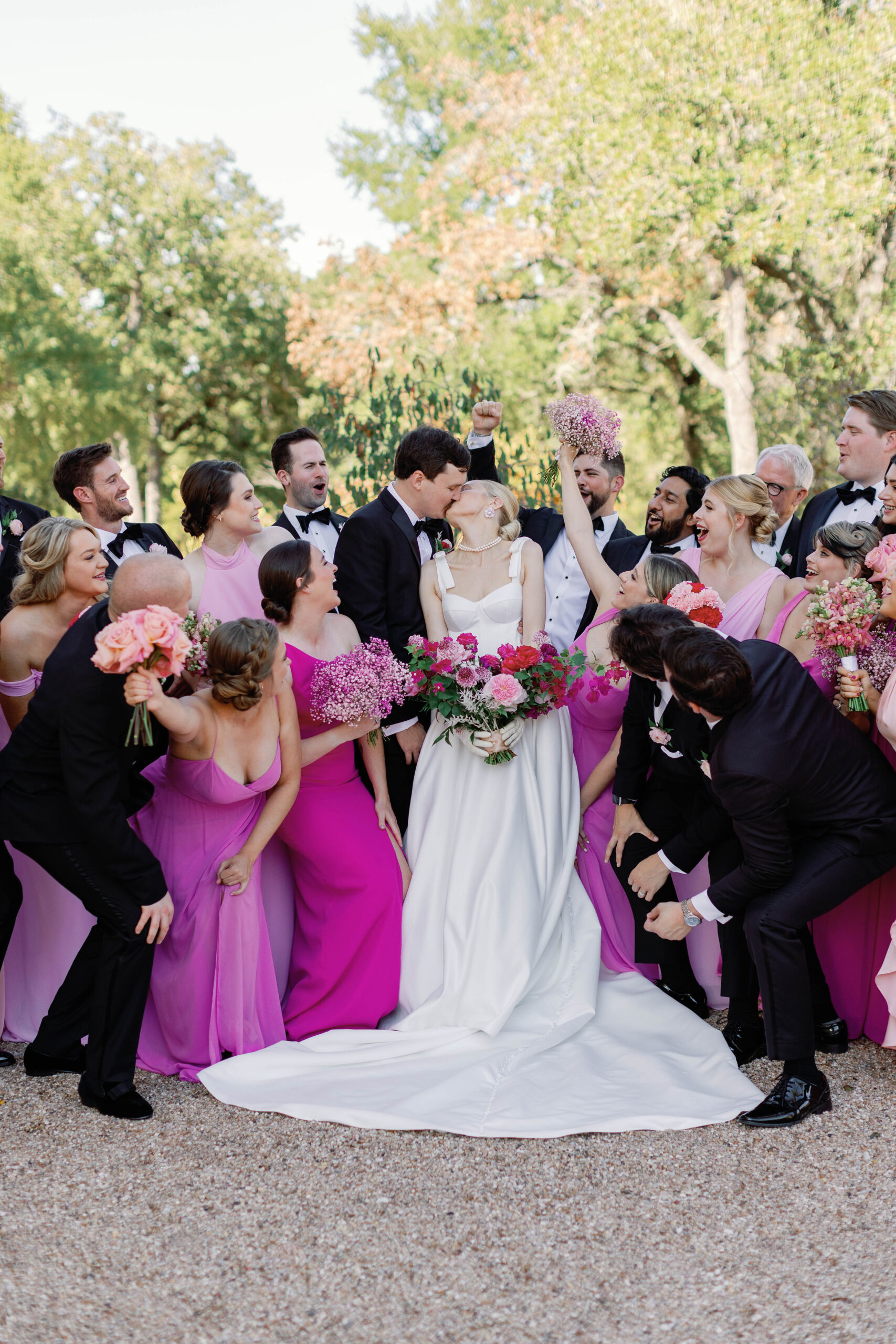 Bride and groom kiss surrounded by their bridal party as they celebrate their wedding at The Grand Lady in Texas. | Photo by Sarah Block Photography